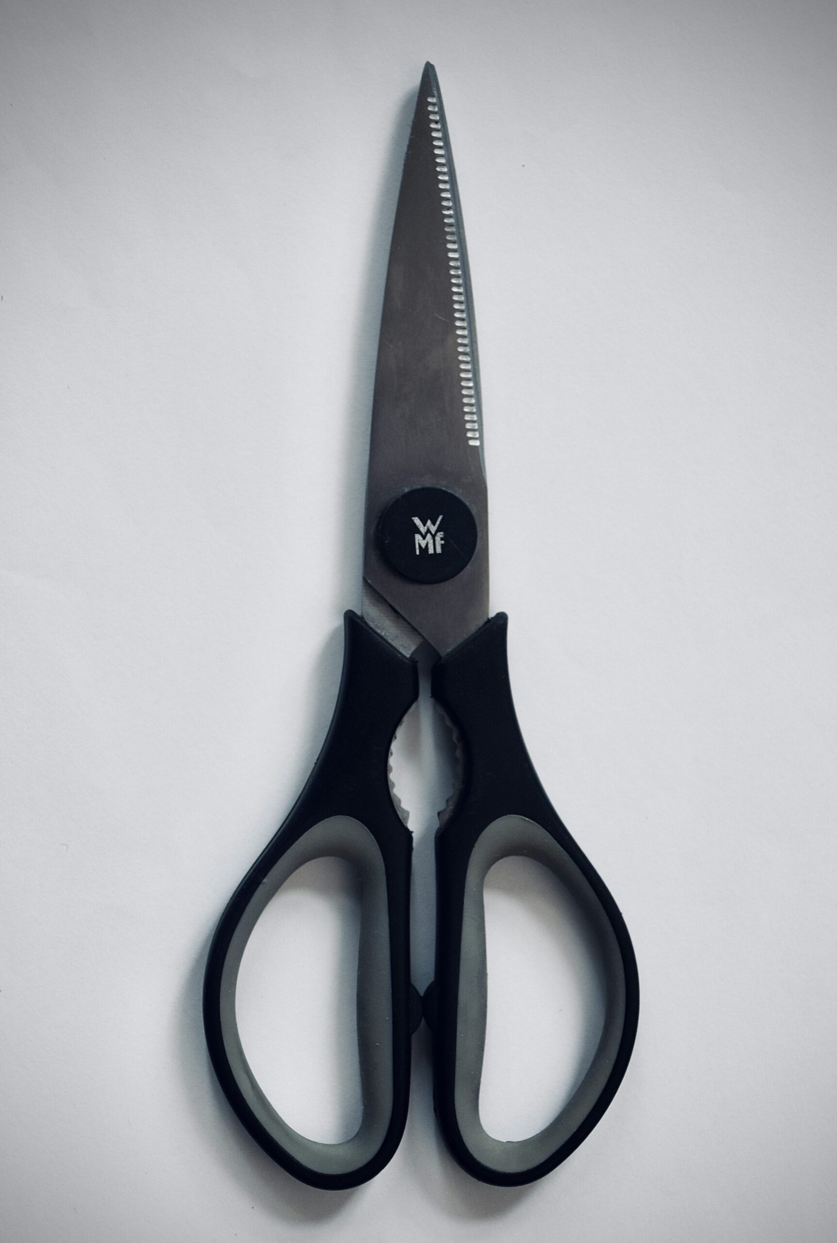 Multi-purpose kitchen shears with stainless steel blades and black ergonomic handles on a white background.