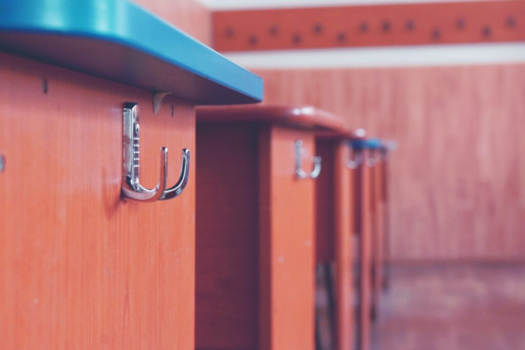 Adhesive hooks on a kitchen cabinet door for hanging cleaning tools